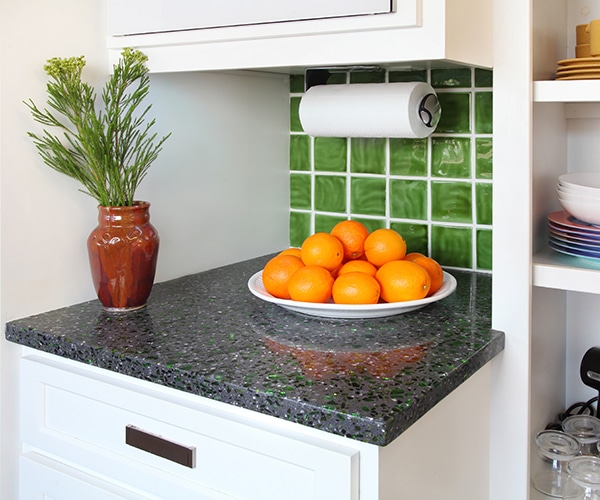 The distinctive countertops in the kitchen get their subtle green hue from recycled Heineken bottles, effortlessly matching the hand-glazed tiles on the backsplash.